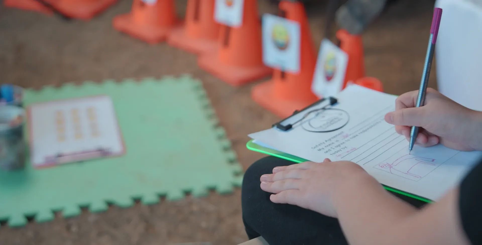 A participant's hands filling in a worksheet on a clipboard during a session